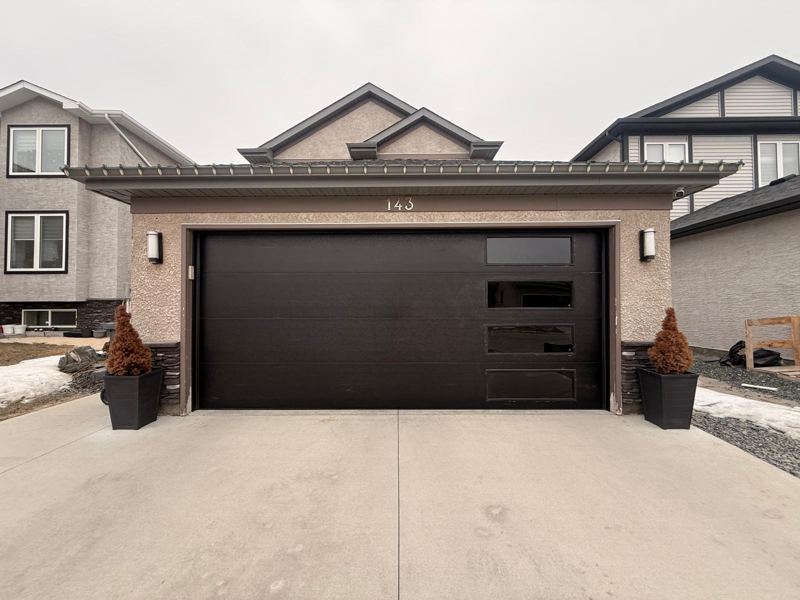 Black modern garage door with side windows on a new home