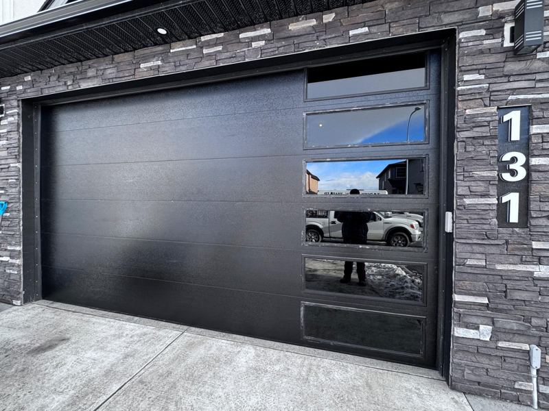 Black flush garage door with a full-view glass side section