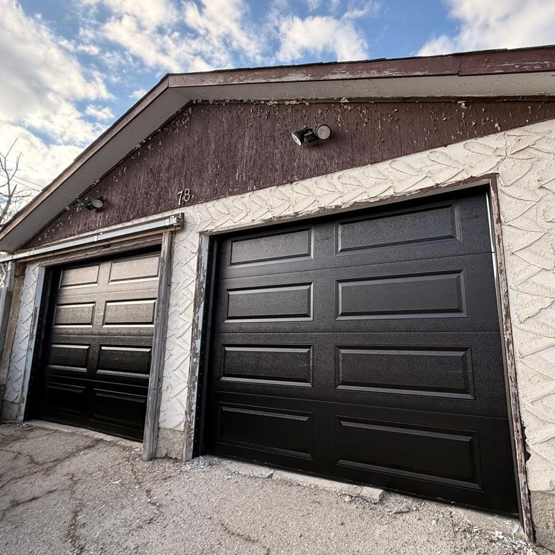 Pair of black long-panel garage doors on a detached garage
