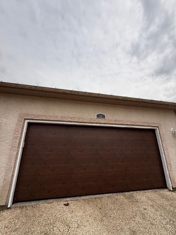 Walnut wood-grain garage door on a stucco garage