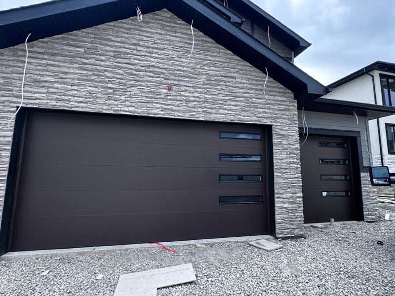 Dark brown flush garage door with side windows on a new home