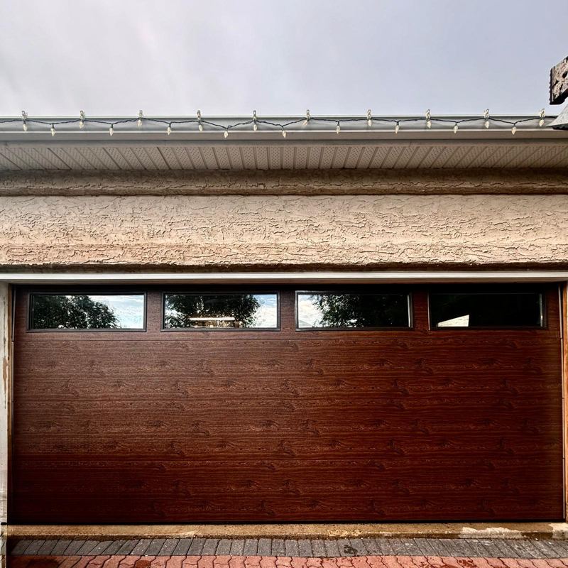 Wood-grain garage door with a row of top windows