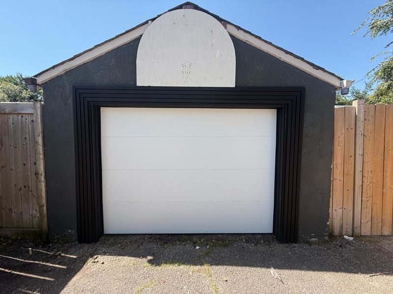 White garage door on a black detached garage