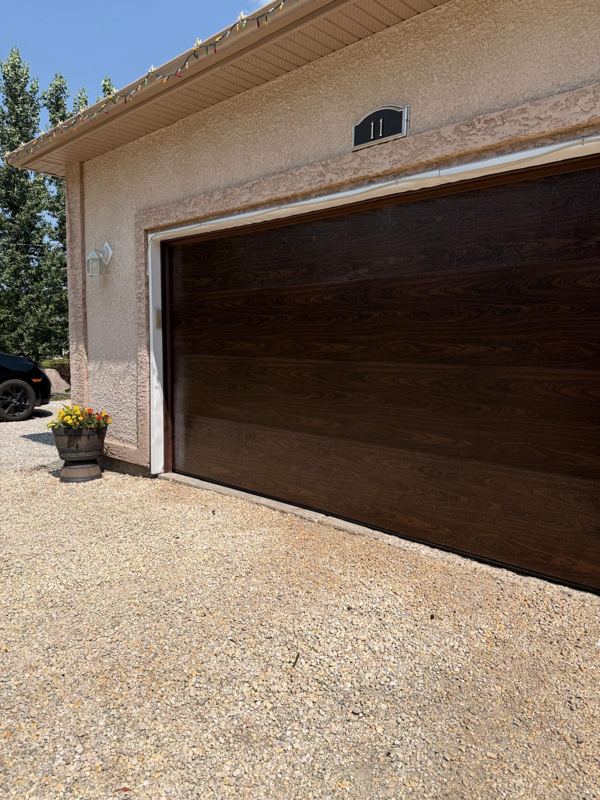 Dark wood-grain garage door on a stucco home