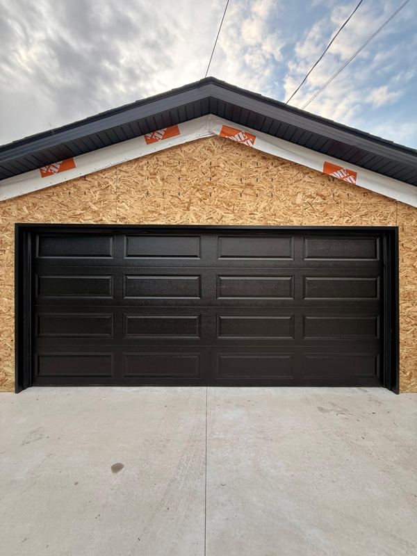 Black long-panel double garage door on a new garage