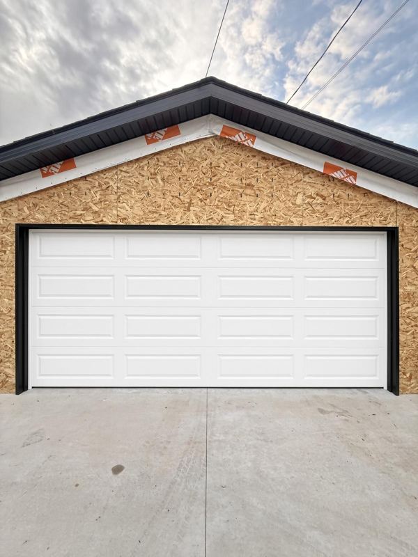 White long-panel double garage door on a new garage
